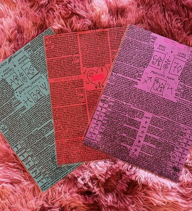 Three of Katie's hand-drawn card charts on teal, red, and pink paper